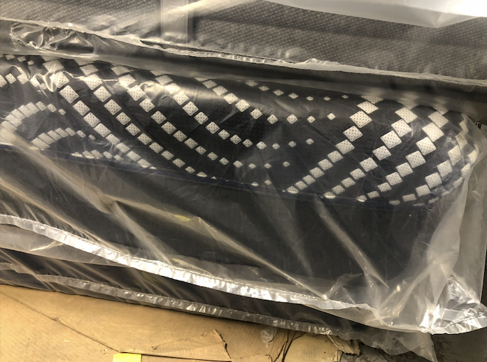 Close view of a wrapped mattress with a diamond-patterned side
