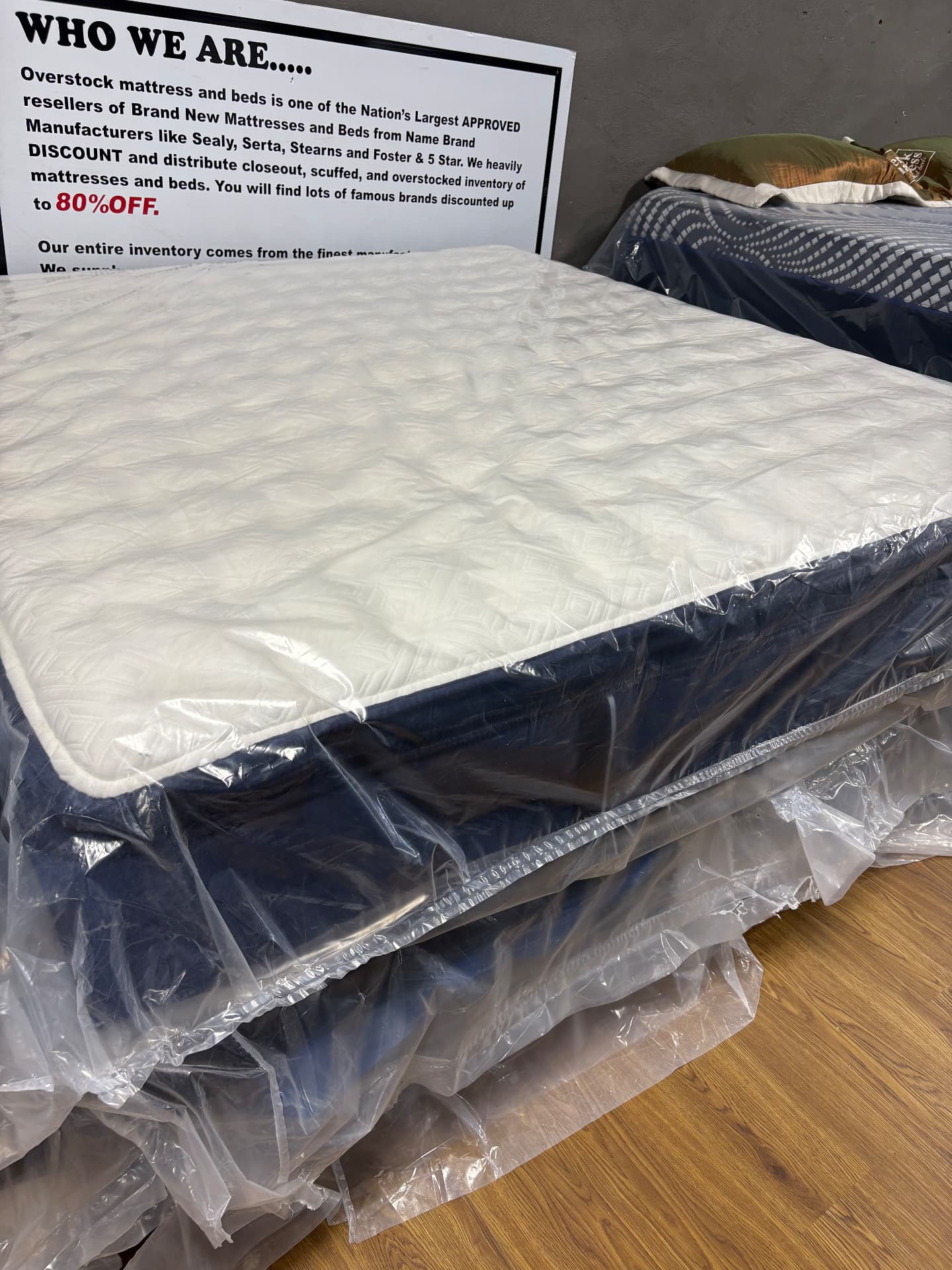 White-topped mattress in protective wrapping at the showroom